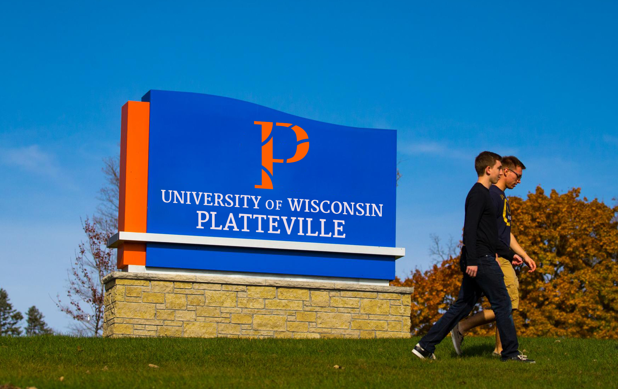 Students walking in front of University of Wisconsin-Platteville outdoor signage displaying the Vendi-created P logo