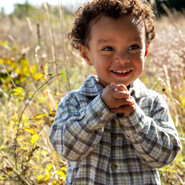 close up of kid smiling in field