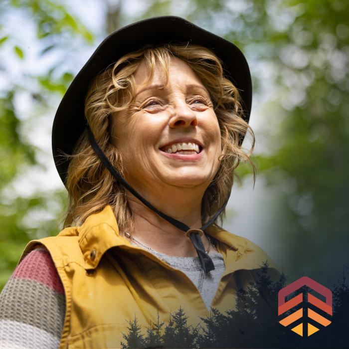 Woman wearing a sun hat while gazing up at the sky.