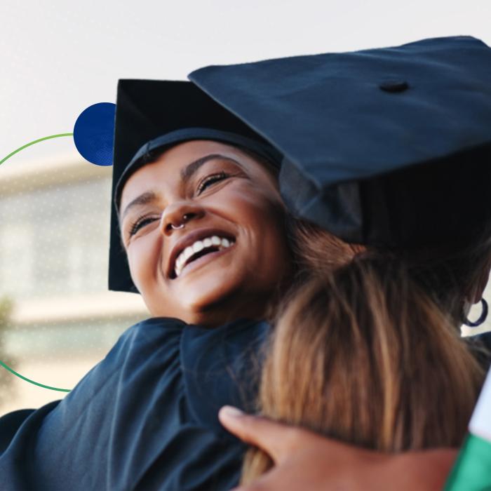 Two female graduates hugging.